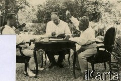 1925-1927, Juan-les-Pins, Francja.
Mężczyźni grają w karty przy stoliku w ogrodzie. W środku siedzi doktor Winterfeld, właściciel pensjonatu 
