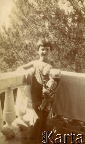 1925-1927, Juan-les-Pins, Francja.
Larysa Zajączkowska na balkonie, w ręku trzyma lalkę. 
Fot. NN, kolekcja Larysy Zajączkowskiej-Mitznerowej, zbiory Ośrodka KARTA