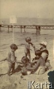 1925-1927, Francja.
Larysa Zajączkowska (z przodu z prawej) spędza czas z babcią Larysą Michelson (z kapeluszem na głowie) i dziećmi na plaży. 
Fot. NN, kolekcja Larysy Zajączkowskiej-Mitznerowej, zbiory Ośrodka KARTA