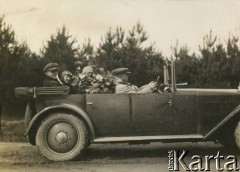Ok. 1928, Rzeczpospolita Polska.
Piotr Zajączkowski (z lewej) z żoną Elżbietą (w środku za kwiatami) jadą samochodem CWS T-1 (Torpedo).
Fot. NN, kolekcja Larysy Zajączkowskiej-Mitznerowej, zbiory Ośrodka KARTA