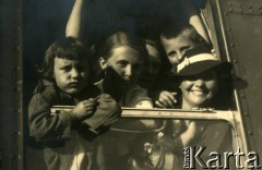 Lato 1938, Jastarnia lub Gdynia, woj. pomorskie, Rzeczpospolita Polska.
Larysa Zajączkowska (2. z lewej) i jej matka Elżbieta (1. z prawej) w otoczeniu dzieci wyglądają z okna w pociągu. 
Fot. NN, kolekcja Larysy Zajączkowskiej-Mitznerowej, zbiory Ośrodka KARTA
