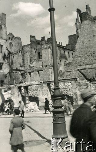 Od sierpnia 1940, Warszawa, Generalne Gubernatorstwo.
Przechodnie na ulicy, w tle widoczne budynki zbombardowane przez lotnictwo niemieckie we wrześniu 1939 roku.
Fot. Larysa Zajączkowska, zbiory Ośrodka KARTA