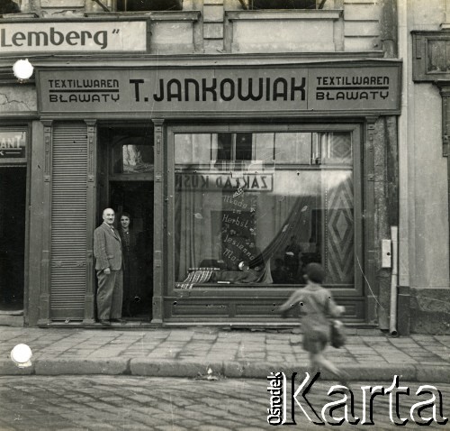 1940, Rzeszów, dystrykt krakowski, Generalne Gubernatorstwo.
Zakład bławatny T. Jankowiak - Textilwaren przy ul. Kościuszki 5 w okresie okupacji niemieckiej. Szyld w językach polskim i niemieckim. W drzwiach stoją prawdopodobnie właściciele zakładu.
Fot. NN, kolekcja Bogusława Kotuli, zbiory Fundacji Ośrodka KARTA