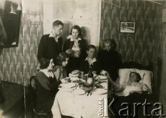 Przed 1939, brak miejsca.
Wigilia Bożego Narodzenia. Rodzina zgromadzona przy stole łamie się opłatkiem.
Fot. NN, zbiory Archiwum Historii Mówionej Ośrodka KARTA i Domu Spotkań z Historią, udostępniła Regina Gutauskiene w ramach projektu 