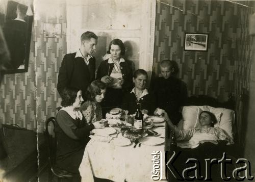 Przed 1939, brak miejsca.
Wigilia Bożego Narodzenia. Rodzina zgromadzona przy stole łamie się opłatkiem.
Fot. NN, zbiory Archiwum Historii Mówionej Ośrodka KARTA i Domu Spotkań z Historią, udostępniła Regina Gutauskiene w ramach projektu 