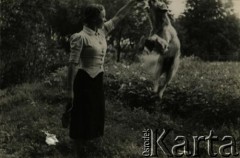 Przed 1939, brak miejsca.
Kobieta podczas zabawy z psem.
Fot. NN, zbiory Archiwum Historii Mówionej Ośrodka KARTA i Domu Spotkań z Historią, udostępniła Felicja Błaszkiewicz w ramach projektu 