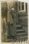 Po 1939, brak miejsca.
Dziewczyna w wojskowym płaszczu zimowym przed domem.
Fot. NN, zbiory Archiwum Historii Mówionej Ośrodka KARTA i Domu Spotkań z Historią, udostępniła Janina Leszczyńska w ramach projektu 