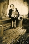 Po 1945, Kazachska SRR, ZSRR.
Kobieta z dzieckiem na kolanach siedzi na schodach domu. 
Fot. NN, zbiory Archiwum Historii Mówionej Ośrodka KARTA i Domu Spotkań z Historią, udostępnił Wasyl Dworecki w ramach projektu 