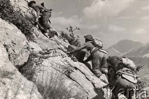 Maj 1944, rejon Monte Cassino, Włochy.
Bitwa pod Monte Cassino. Żołnierze ze skrzynkami amunicji wspinający się na pozycje na zboczu góry.
Fot. NN, zbiory Instytutu Józefa Piłsudskiego w Londynie.
